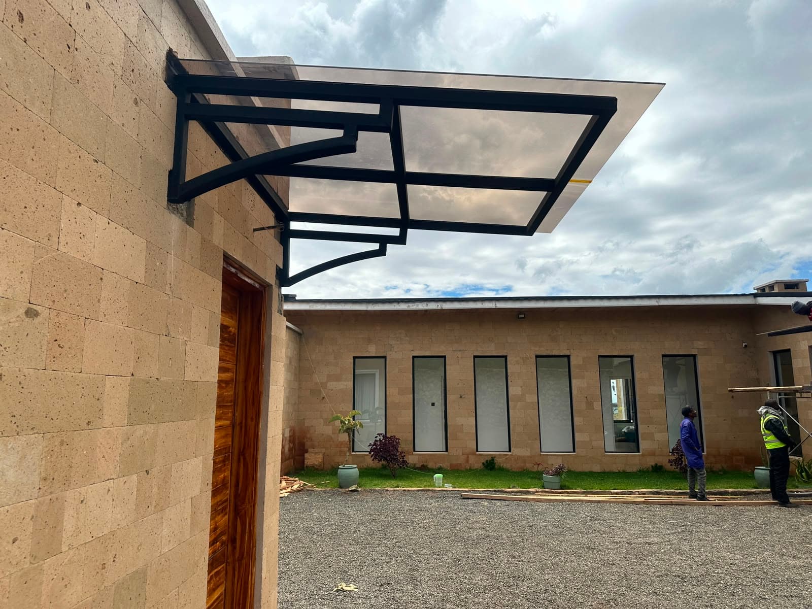 Wall-mounted polycarbonate entrance canopy with clean steel detailing